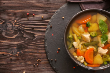 Bowl with delicious turkey soup on slate plate