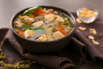 Bowl with delicious turkey soup on brown napkin, close up