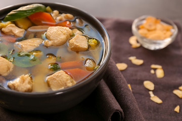 Bowl with delicious turkey soup on brown napkin, close up