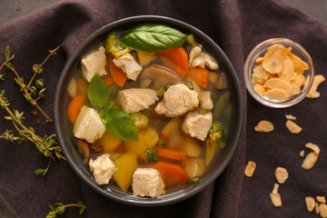 Bowl with delicious turkey soup on brown napkin