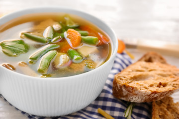 Bowl with delicious turkey soup on table, close up