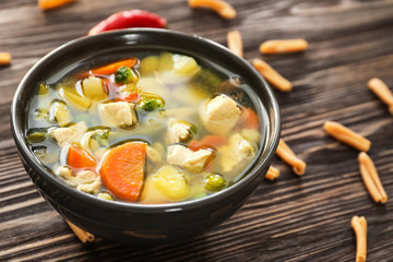Bowl with delicious turkey soup on wooden table