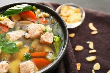 Bowl with delicious turkey soup on napkin, close up