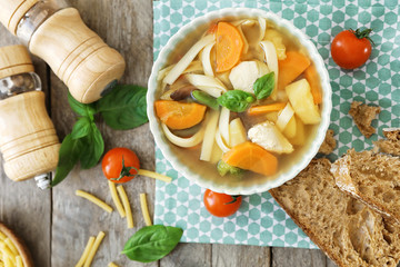 Bowl with delicious turkey soup on wooden table