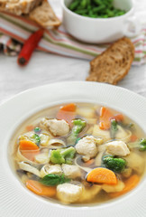 Plate with delicious turkey soup on table