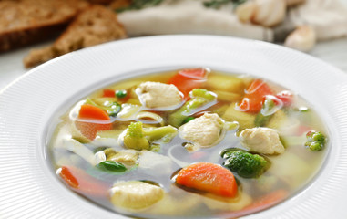 Plate with delicious turkey soup on table