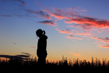 Sad girl on sunset background, silhouette.