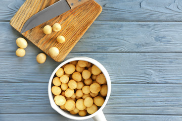 Saucepan with raw organic potato on wooden table