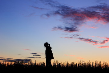 Fototapeta premium Sad girl on sunset background, silhouette.