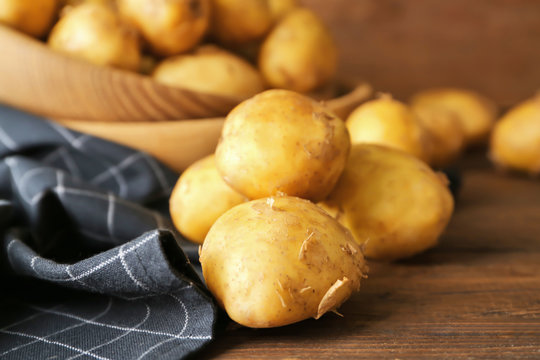 Raw organic potato on wooden table
