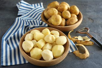 Composition with bowls of raw organic potatoes on table
