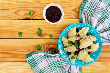 Delicious dumplings with cherry on wooden background