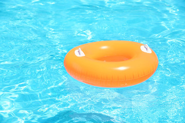 Inflatable orange ring in blue swimming pool