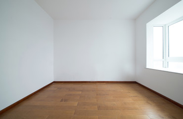 Light empty room with big white isolated window and wooden floor