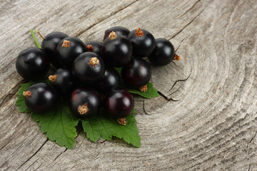 black currant with green leaf on old wooden background