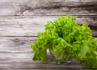 Fototapeta premium Lettuce leaves on a wooden background