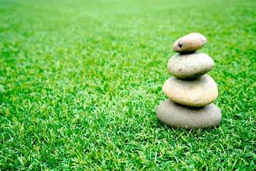 Fototapeta na wymiar stones stacked up on grass