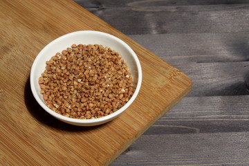 Buckwheat groats in a plate on a wooden table