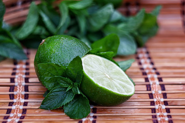  Juicy ripe lime and mint on a wooden table