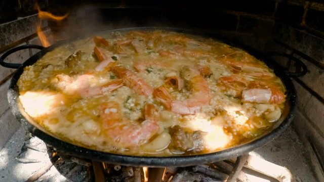 Famous typical spanish rice dish. Spanish paella. Everyday cooking with natural fire. 4k shoot