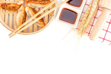 Japanese food, Gyoza dumplings in bamboo basket, serve with chopsticks and napkin isolated on a white background. Top view with copy space and text.