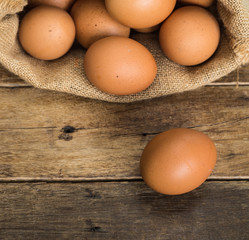 chicken eggs in brown gunny sack on wooden table