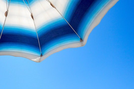 Ombrellone in primo piano con sfondo blu