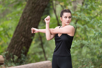 Sportswoman Stretching Arm in the Forest