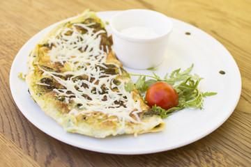 Hot pizza slice with melting cheese on a rustic wooden table. Delicious meal in the restaurant on a sunny day.