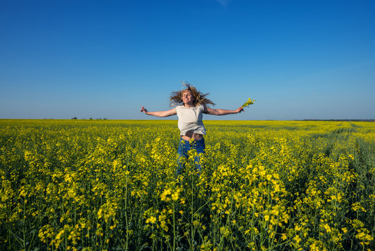 Happy young woman, with flying hair and open arms jumping
