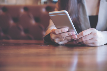 A business woman holding and using smart phone in modern cafe
