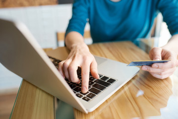 Hands typing on computer keyboard while making online payment from credit card