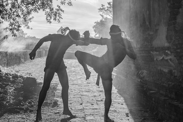 Obraz na płótnie Canvas Muay thai, Black and White Thai Boxer training in sunset background,Thai boxer culture,Thailand