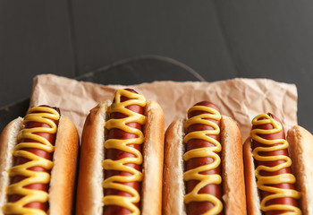 Barbecue Grilled Hot Dogs with  yellow American mustard, On a dark wooden background