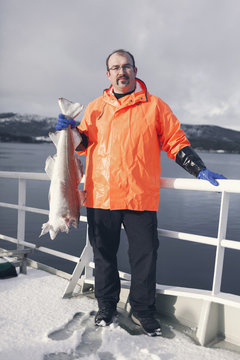 A Norwegian ships captain holds up a freshly caught cod