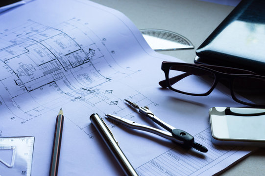 Divider, Pencil, Pen, Ruler, Glasses And Smartphone And Blueprint On Table Top.Table Top View Of Engineers Table At Office Workplace.selective Focus.