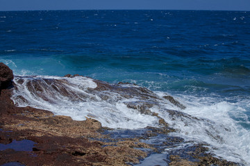 Stony ocean shore. Coast of the ocean on the islands. Canary Islands. Spray of the ocean