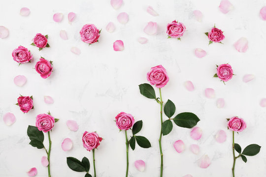 Beautiful pink rose flowers on white table top view. Wedding mockup in flat lay style.