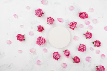 Wedding mockup with white round blank, pink rose flowers and petals on light table top view. Beautiful floral pattern. Flat lay style.