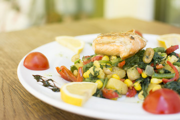 Delicious salad with chicken and vegetables. Caesar Salad with grilled chicken on a white plate.