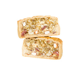Moon cakes stuffed with five nuts; almond, walnut, white sesame, watermelon seeds, cashew nuts cut in half and stack for layers isolated on white background (clipping path included)