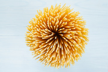 bouquet of raw spaghetti standing on a white wooden surface
