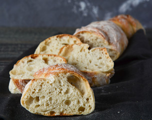 Fresh homemade chopped bread on a wooden background.