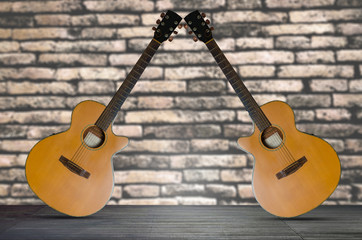 Fototapeta na wymiar two acoustic guitar on the wooden floor against brick wall background.