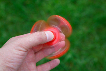 Closeup red fidget spinner in hand. Popular spinner gadget