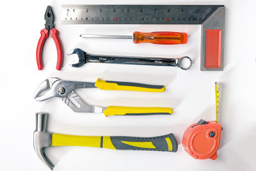 Top view of Working tools,wrench,socket wrench,hammer,screwdriver,plier,electric drill,tape measure,machinist square on white background. flat lay