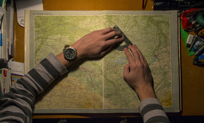 The cartographer works with the protractor on the map