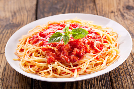 plate of pasta with tomato sauce and green basil