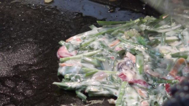 4K Bindae-tteok in Gukje International Market Busan city. Bindaetteok, fried buchimgae, savory pancake with ground mung beans, vegetables, meat. Korean vendors selling food in street, South Korea-Dan