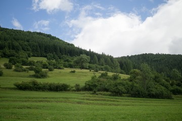Fototapeta na wymiar Green meadow and hills during sunny and cloudy afternoon. Slovakia
